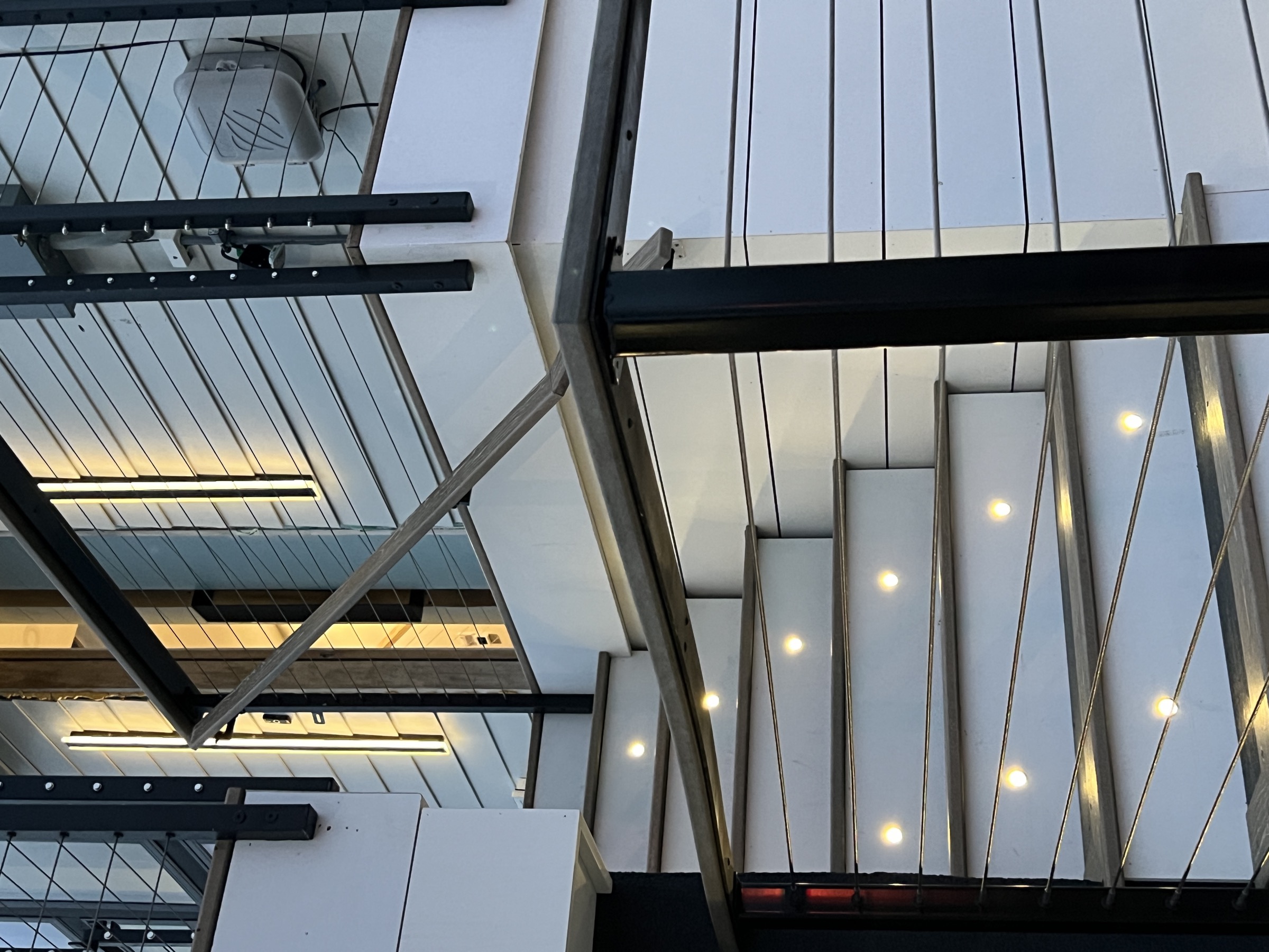 Exterior cable railing staircase at dusk with glowing step lights at a Jersey Shore home.